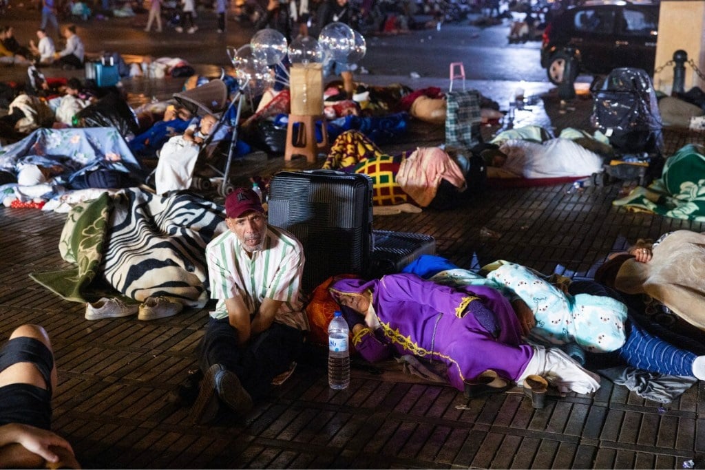 People sleeping outdoors huddled together in crowd